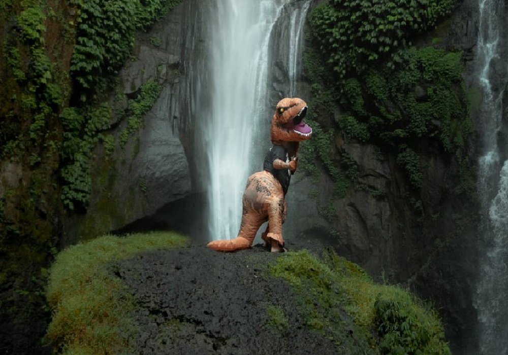 person posing in dinosaur statue